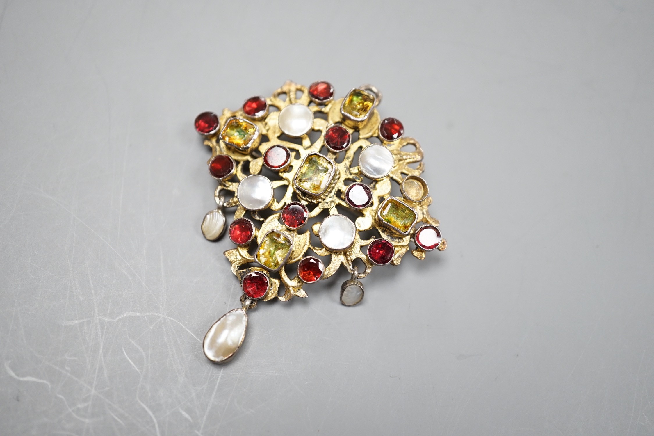 An Indian? gilt white metal and multi gem set drop pendant brooch, (stone missing), 54mm.